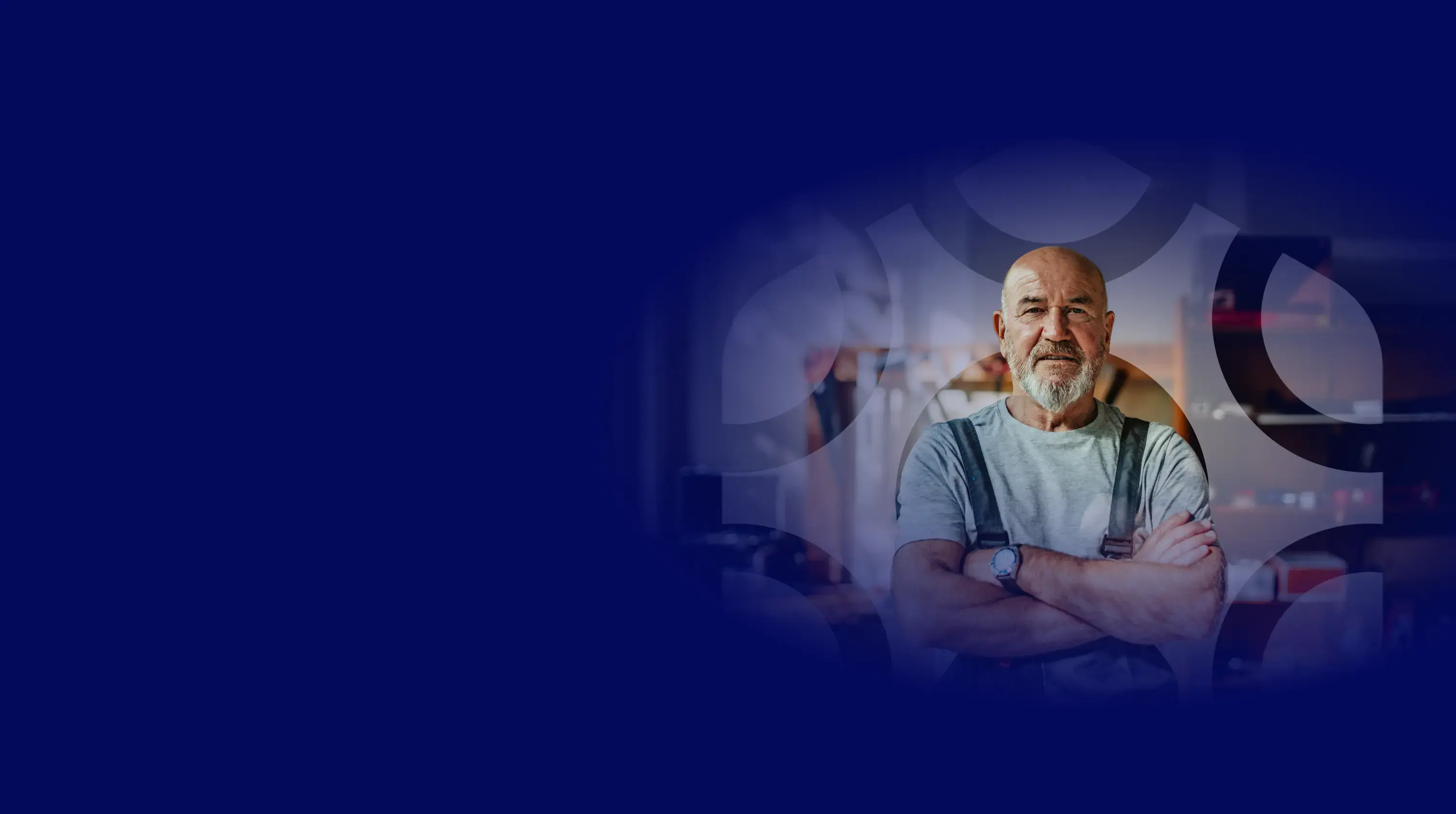 A deep blue background covers the top of the page, with a watermarked version of the hexagonal logo shape overlaid on an image of a mature man wearing a hat, with his arms crossed standing in a workshop, looking confident and in control.